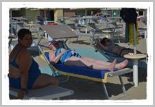 Gli ospiti di Villa Marina in spiaggia possono prendere il sole o stare all'ombra degli ombrelloni
